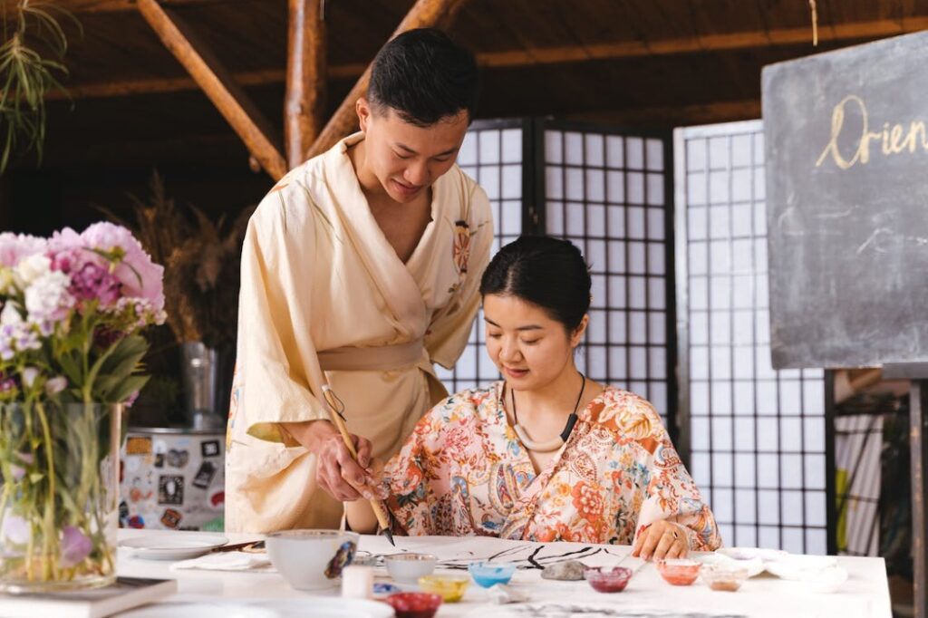 Two people participating in an art workshop getting them closer to the culture of study